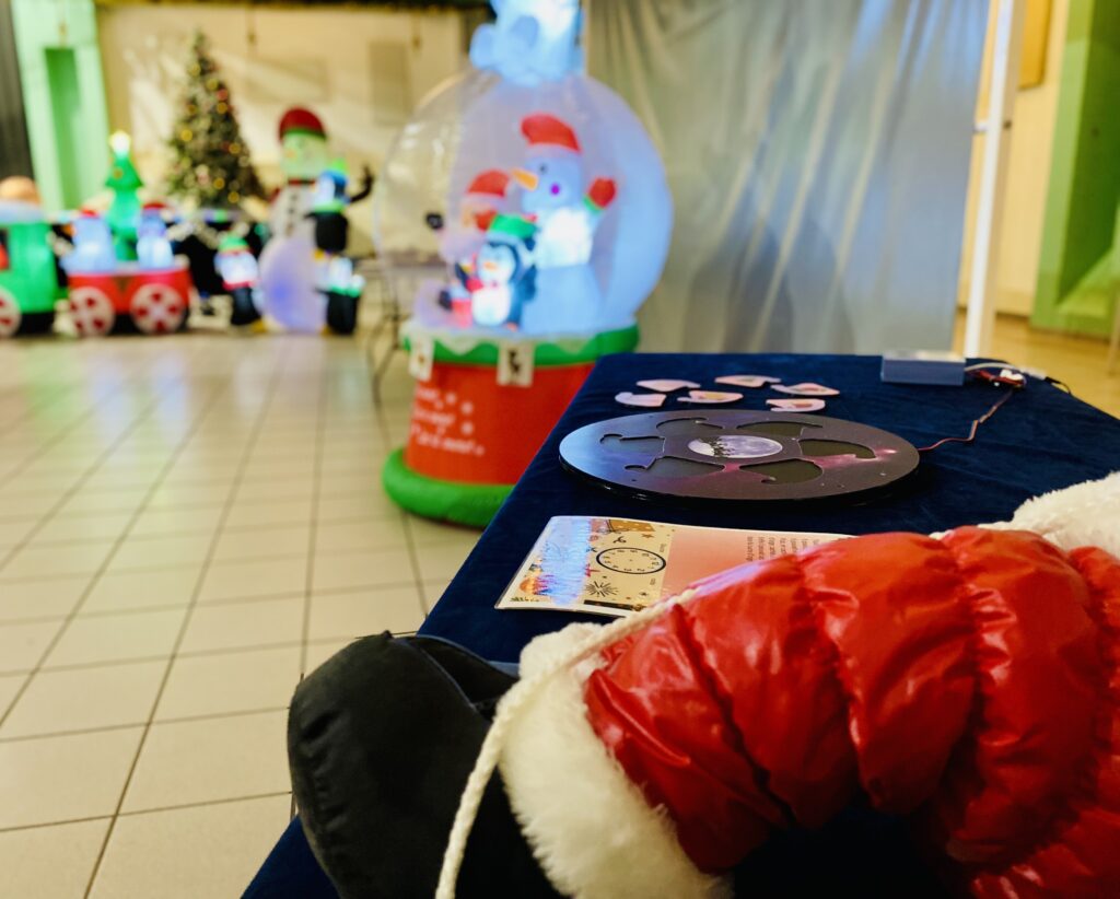 Table d'énigmes et globe de neige gonflable, décor de la balade aux énigmes La Magie de Noël