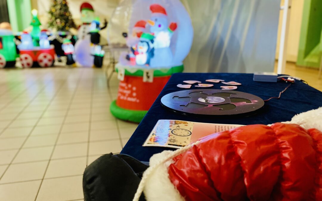 Table d'énigmes et globe de neige gonflable, décor de la balade aux énigmes La Magie de Noël